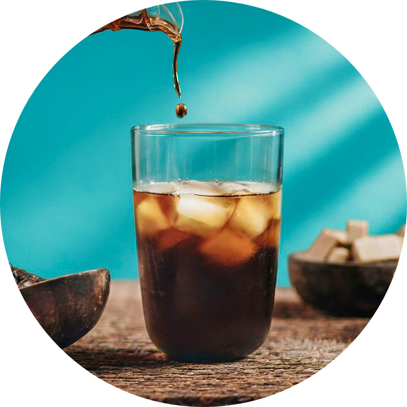 Cold Brew being poured into a clear glass with ice