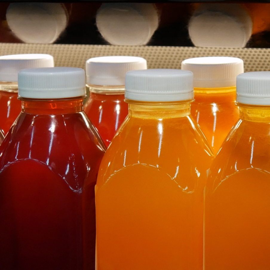 row of beverage bottles filled with liquid sitting next to each other