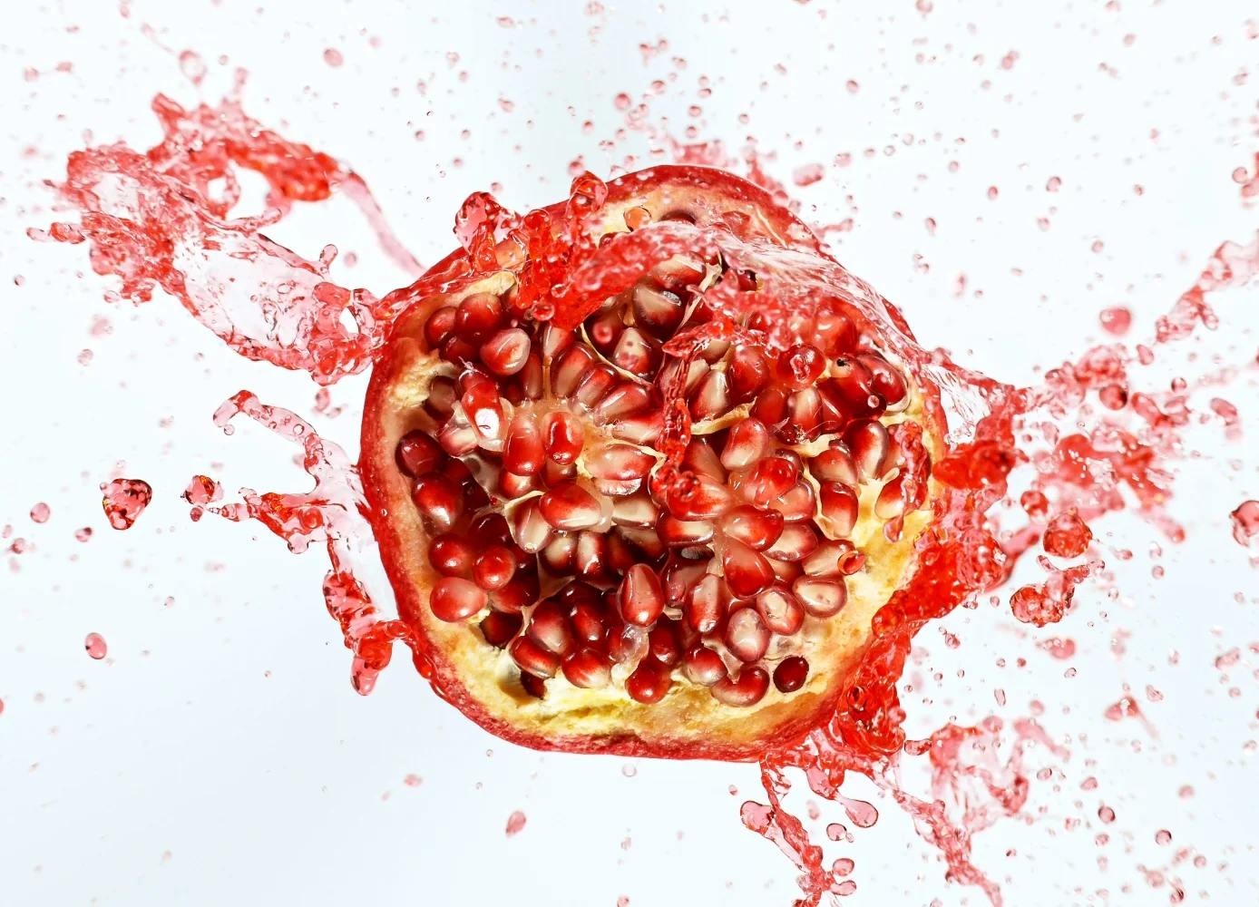 pomegranate that has been sliced in half, often used as an ingredient in beverages and manufacturing