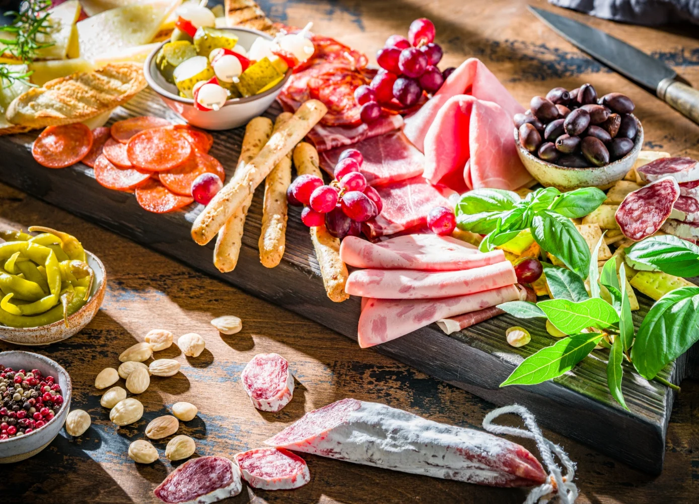 wooden table topped with lots of different types of food and beverages