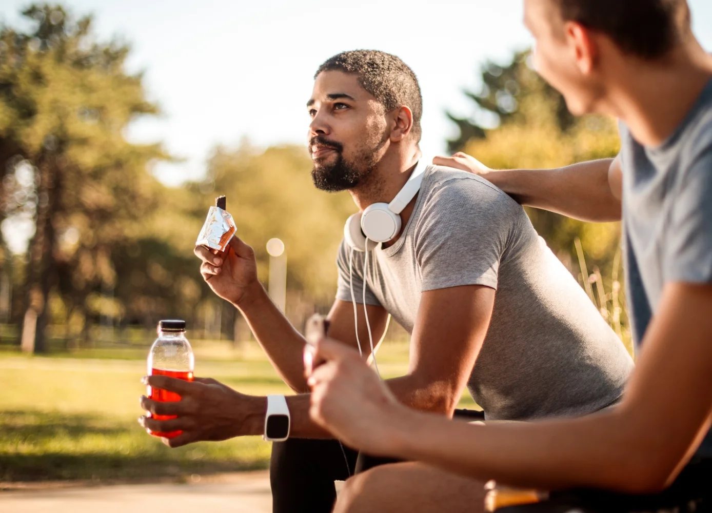 couple of men sitting next to each other enjoying beverages