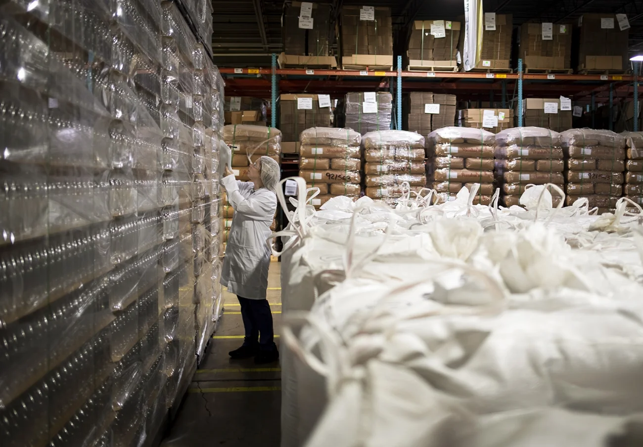 warehouse filled with lots of white bags containing ingredients for manufacturing beverages